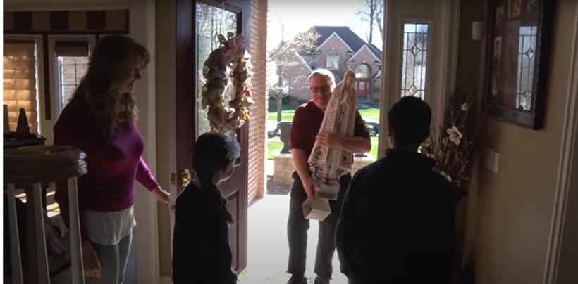 A group of people are standing in a doorway of a house ready for a home cosnecration