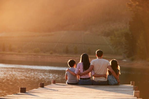 family sitting together on a dock