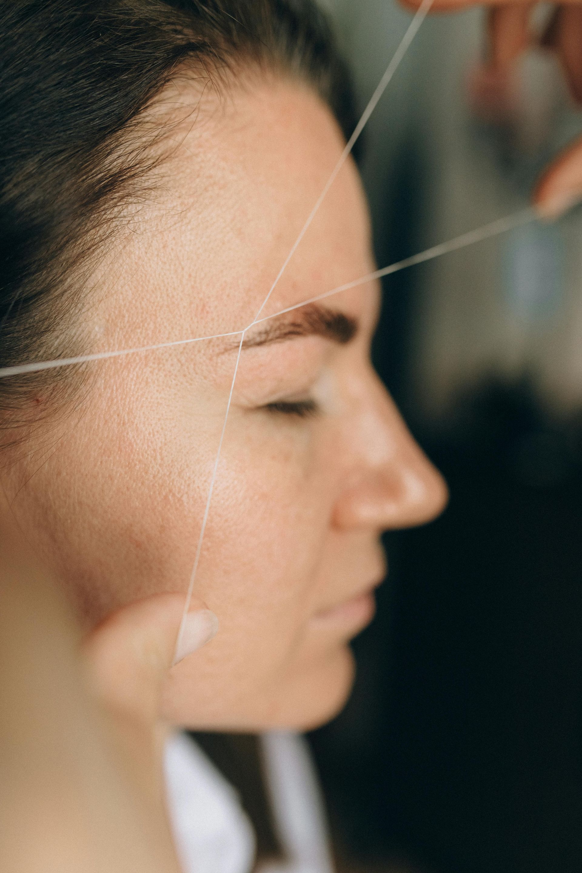A woman is getting her hair cut by a hairdresser in a salon.