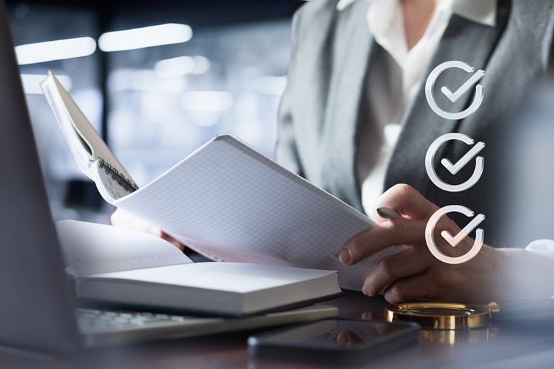 Person in a gray suit reviewing documents, checklist icons overlaid.