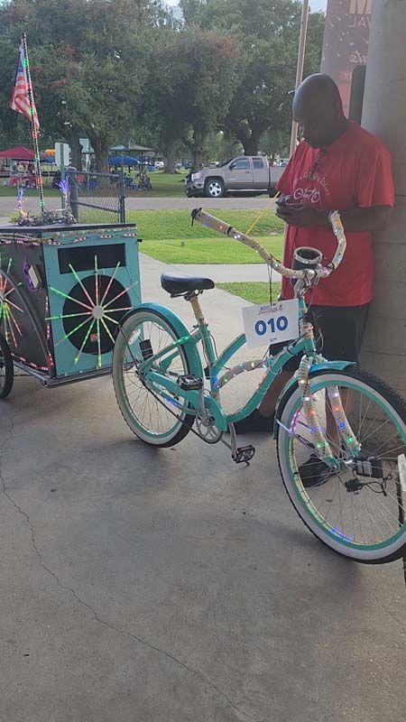 A man is standing next to a bicycle with the number 010 on it.