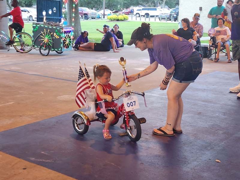A little girl on a tricycle with the number 207 on it