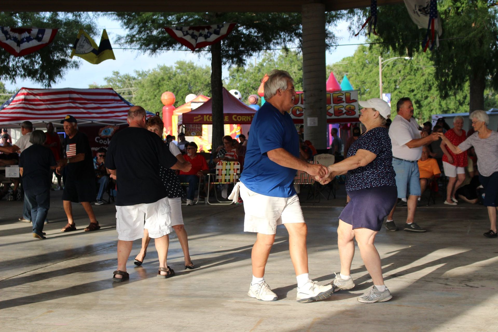 A group of people are dancing under a tent that says ice cream