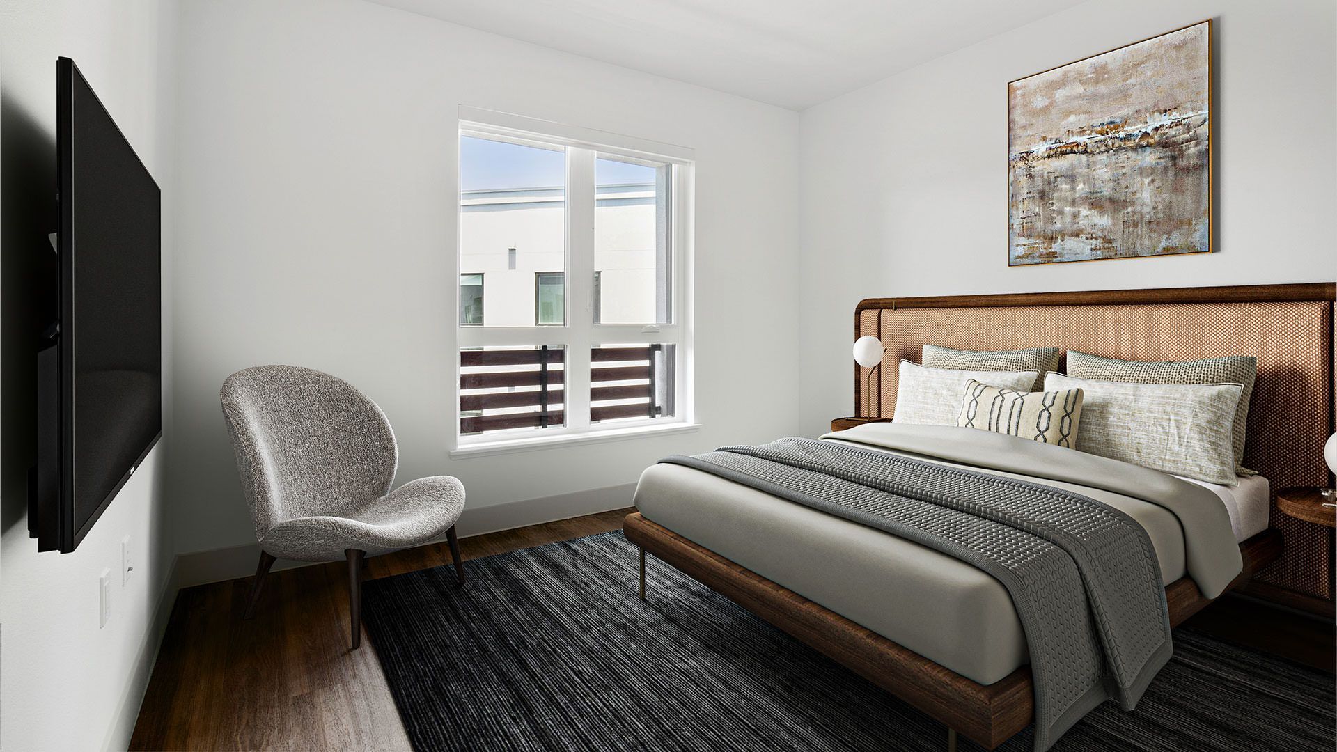 Bedroom with bed, window, chair, TV, and abstract art at The Waymark in Walnut Creek, CA.
