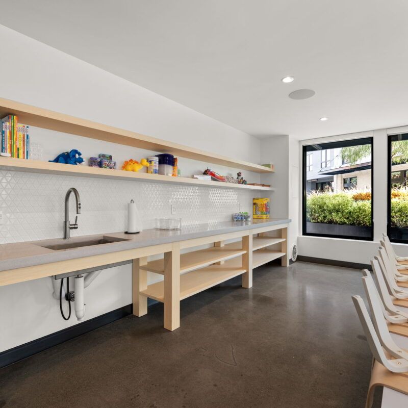 Art room with a sink, long counters, shelves, and windows overlooking greenery at The Waymark in Walnut Creek, CA.
