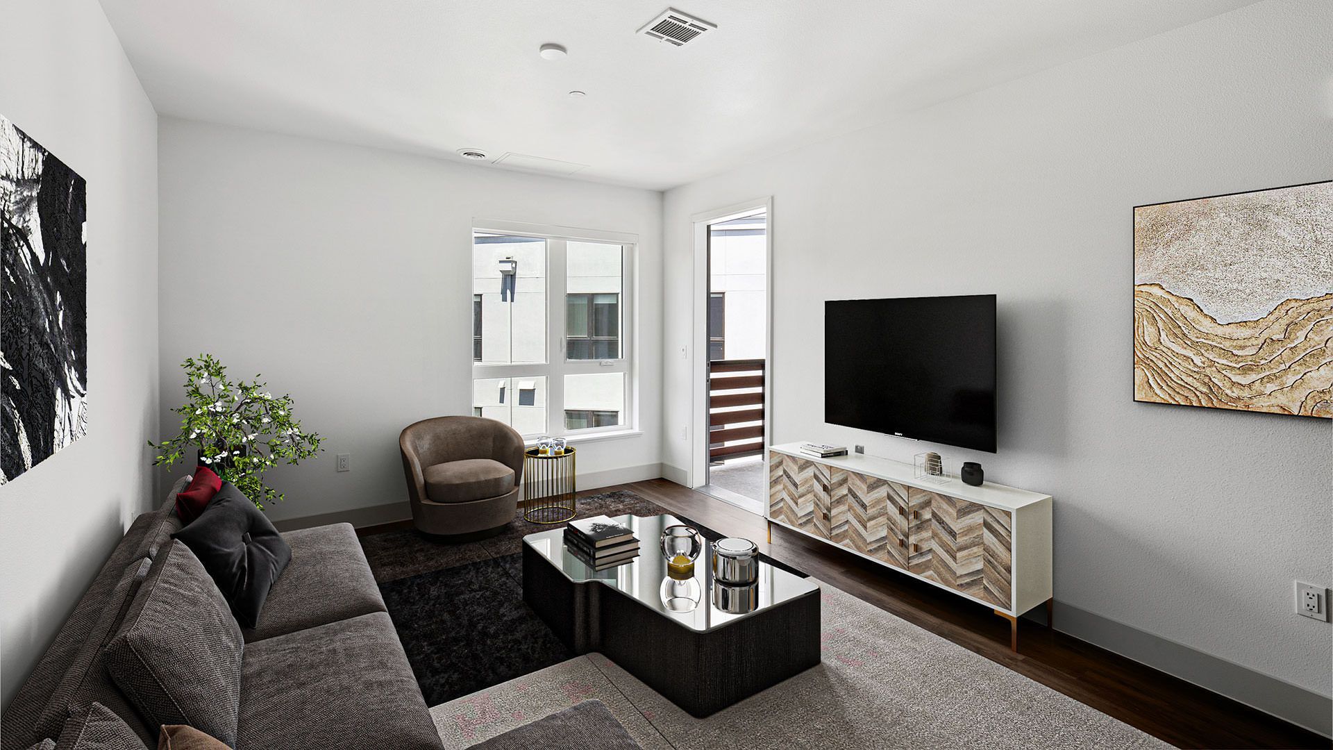 Modern living room with gray sofa, TV, and art at The Waymark in Walnut Creek, CA.