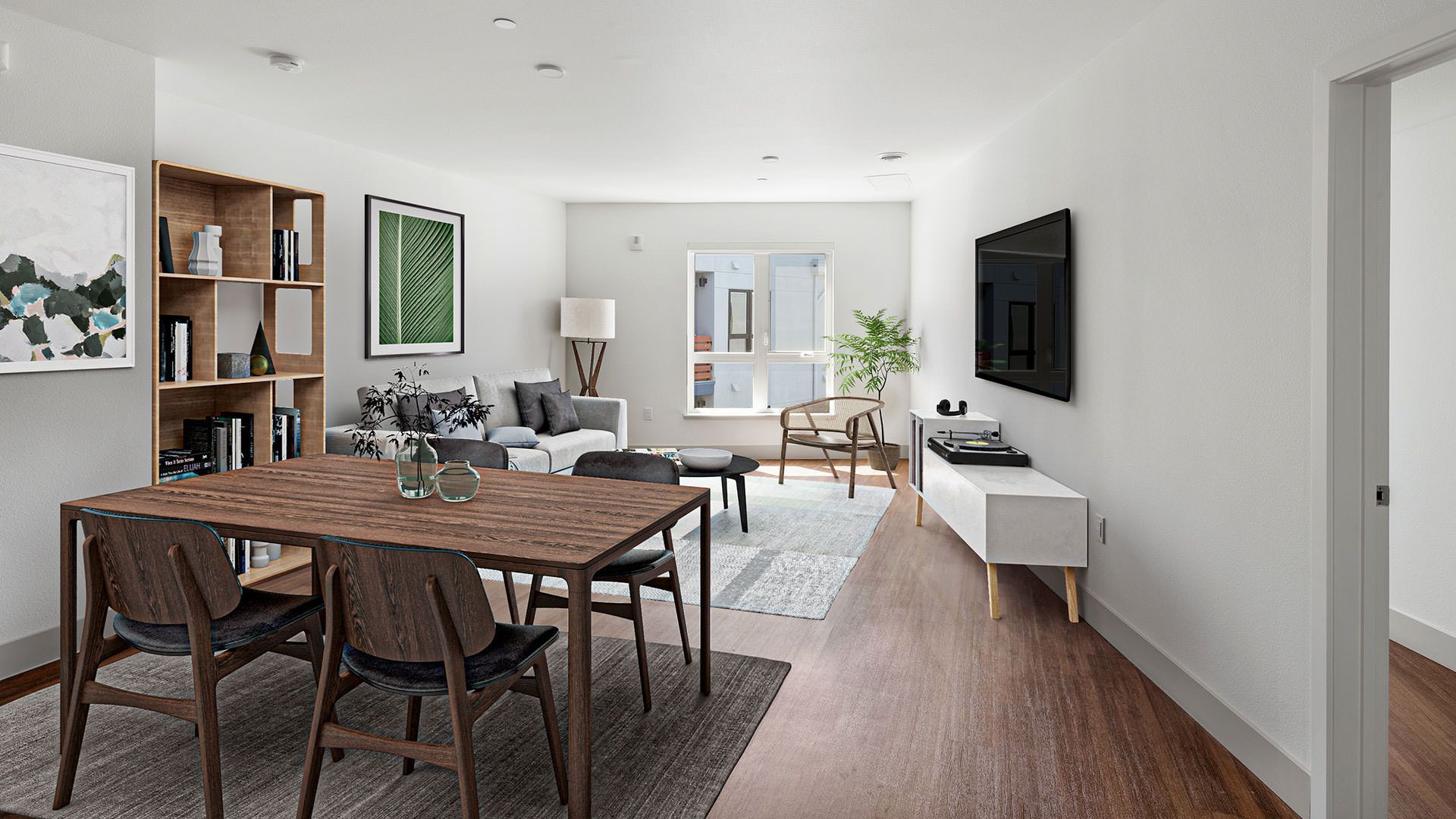A bright, modern living/dining room with dark wood table, white walls, and a mounted TV at The Waymark in Walnut Creek, CA.