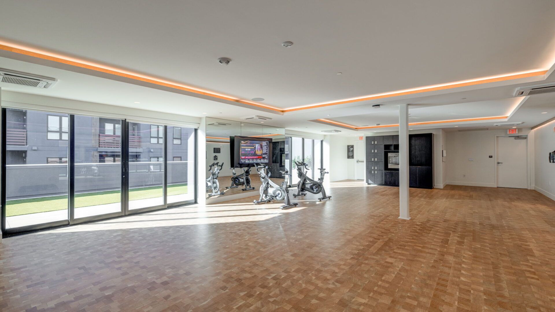 Modern gym with exercise bikes, large windows, and wood flooring at The Waymark in Walnut Creek, CA.