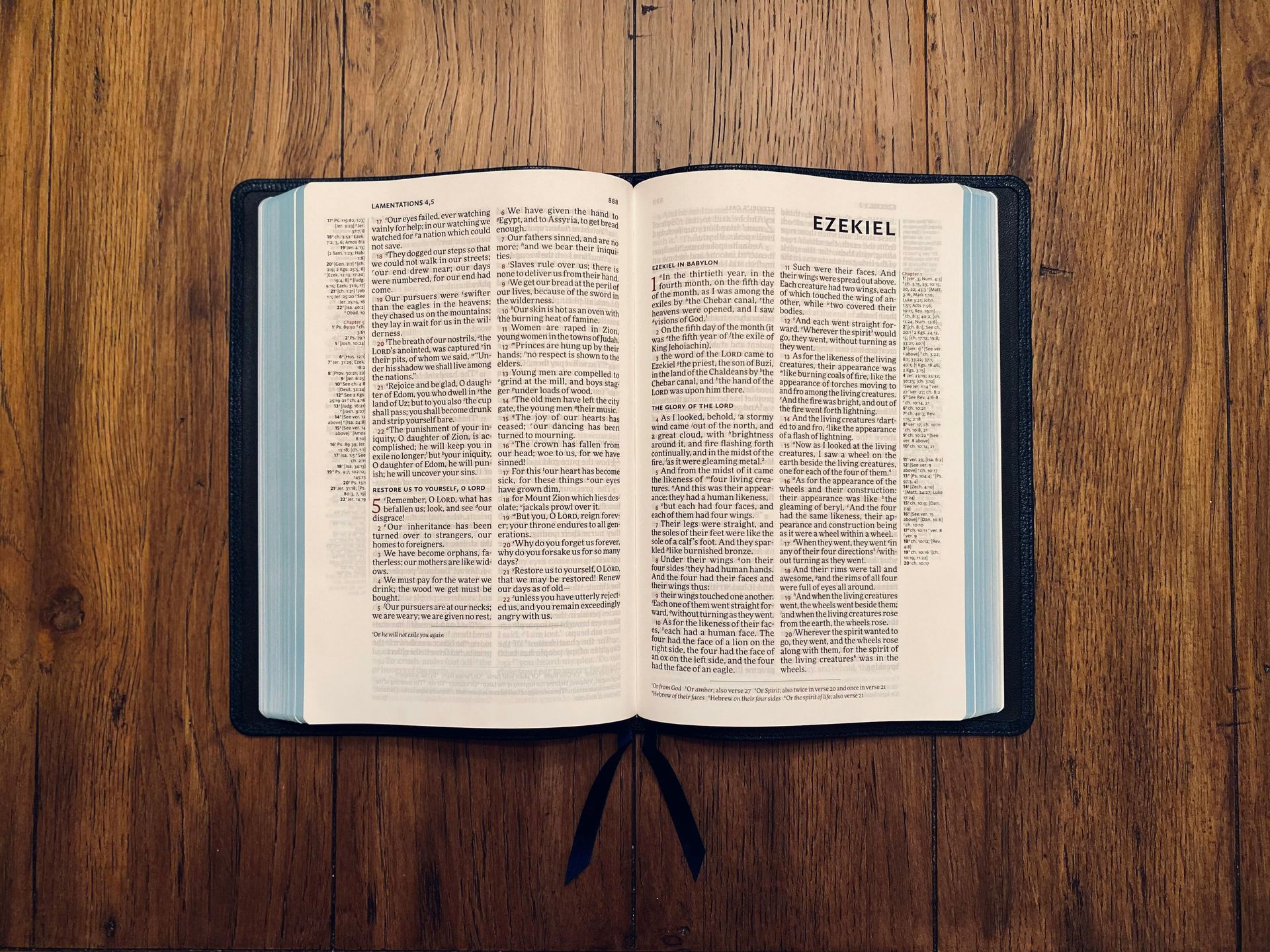 An open book with two columns of text lies flat on a dark, rustic wood grain background.