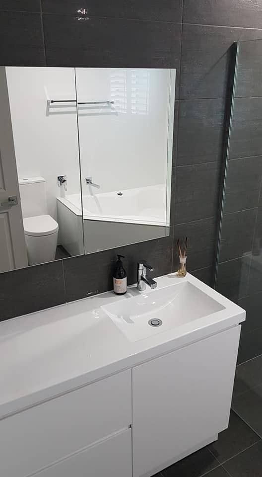 A Bathroom With A Sink, Mirror, Toilet And Bathtub — The Kitchen & Bathroom Doctor in Medowie, NSW