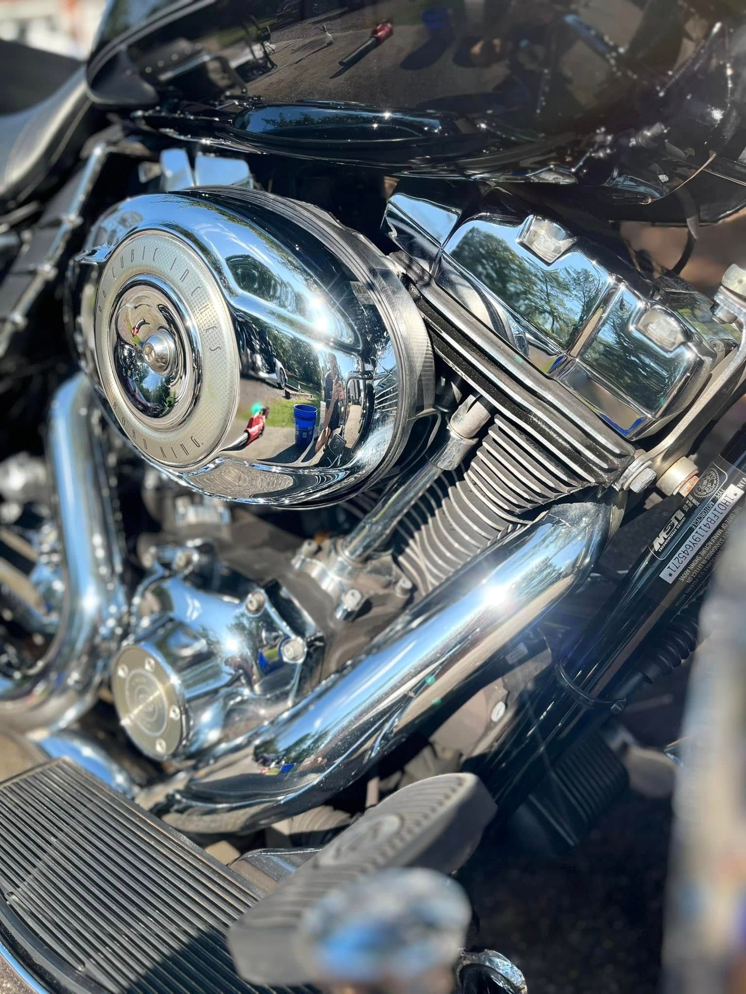 Chrome motorcycle engine close-up with shiny polished parts and foot pedal.