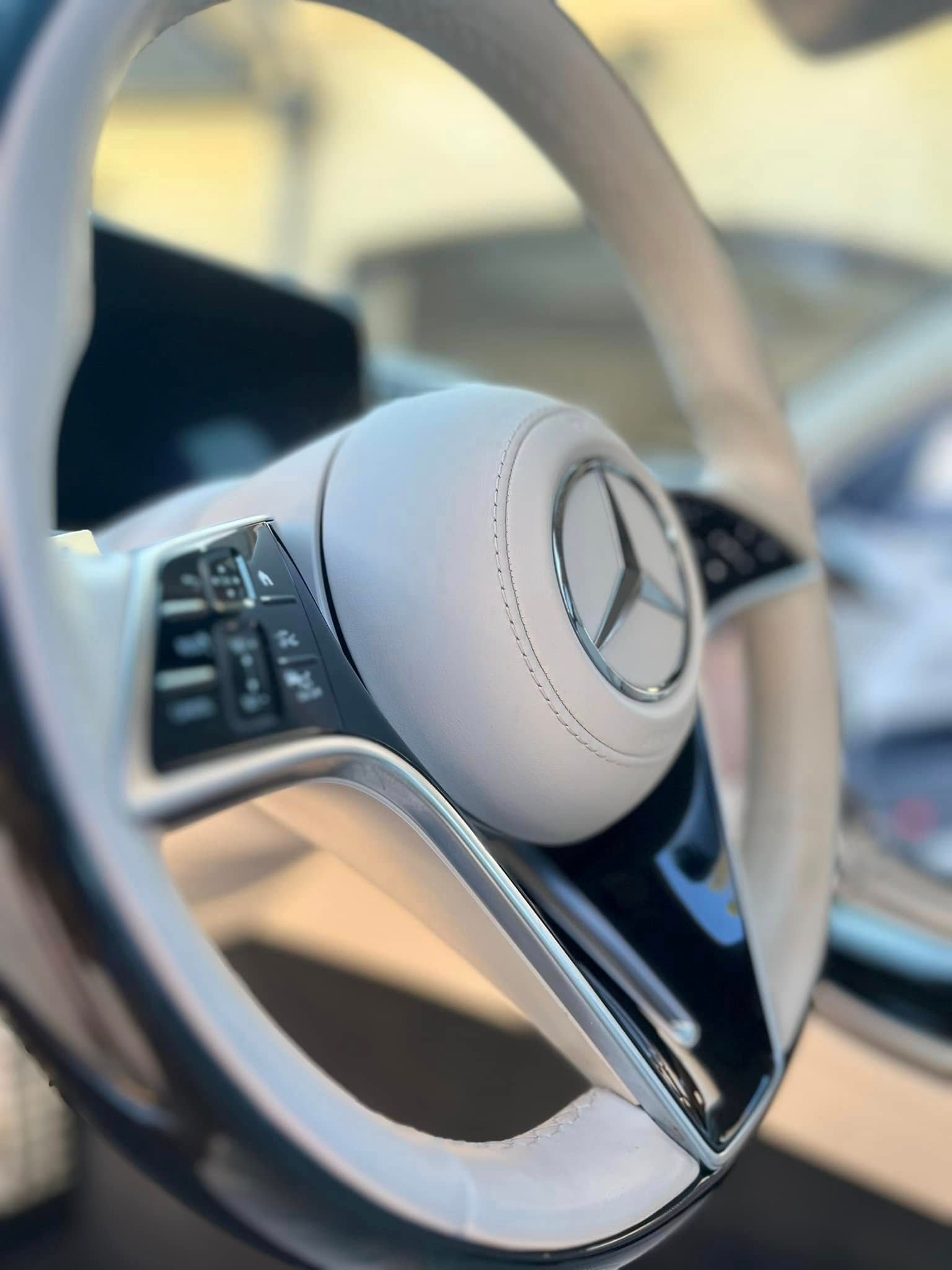 Close-up of a Mercedes-Benz steering wheel with silver trim inside a car interior