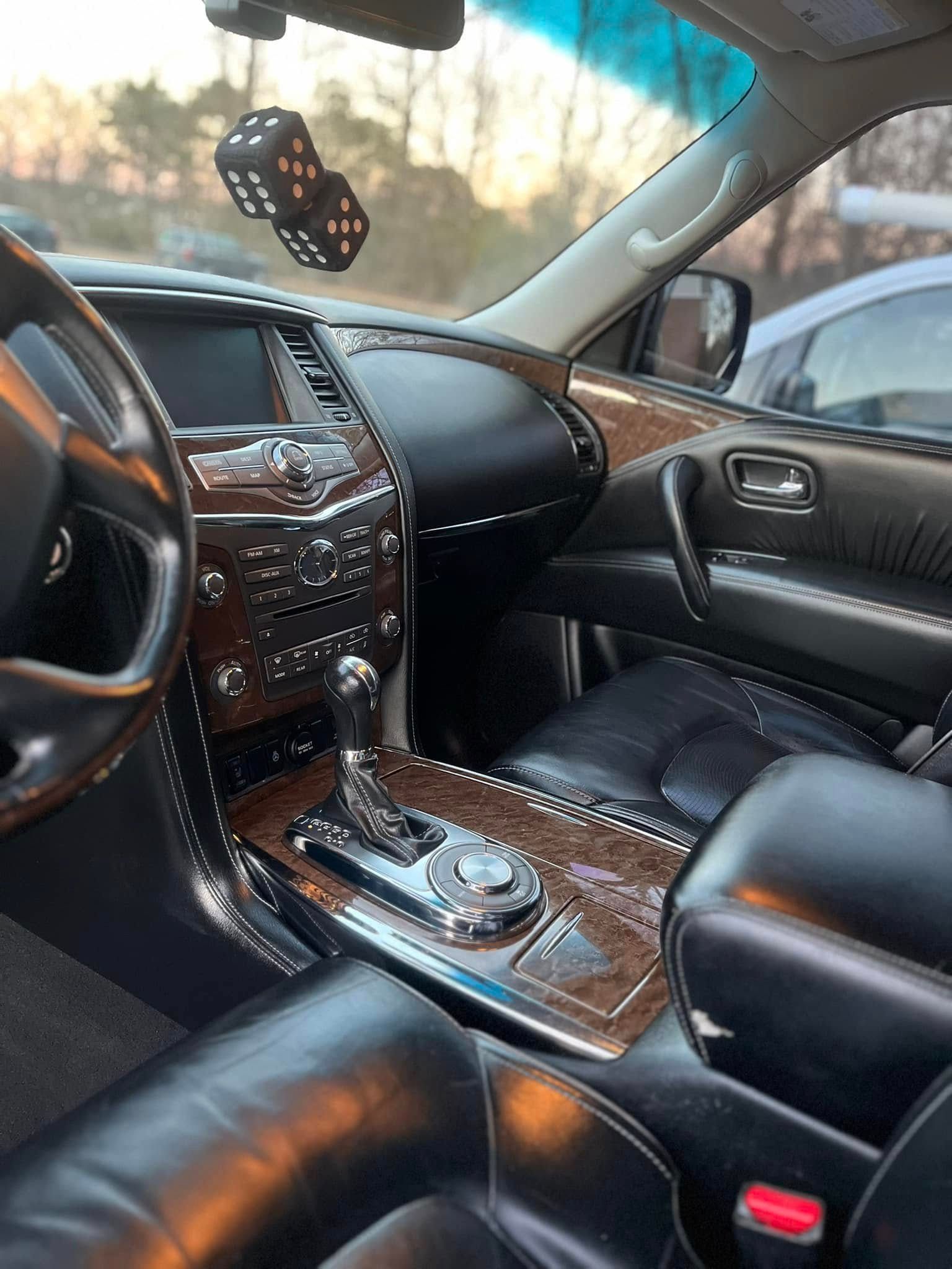 Luxury car interior with black leather seats, wood trim, and dashboard controls