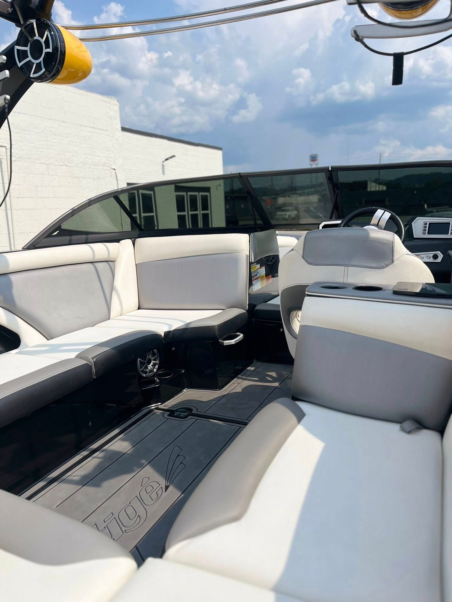 White boat seating on a deck with a black floor and blue sky above