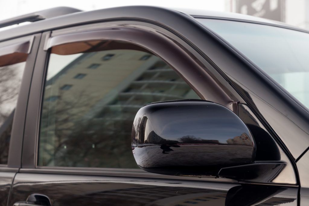 Black SUV side view with tinted windows and a side mirror.