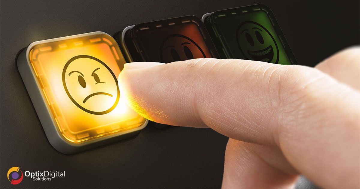 Finger pressing a glowing yellow sad-face app icon on a dark surface, with dim red and green icons nearby