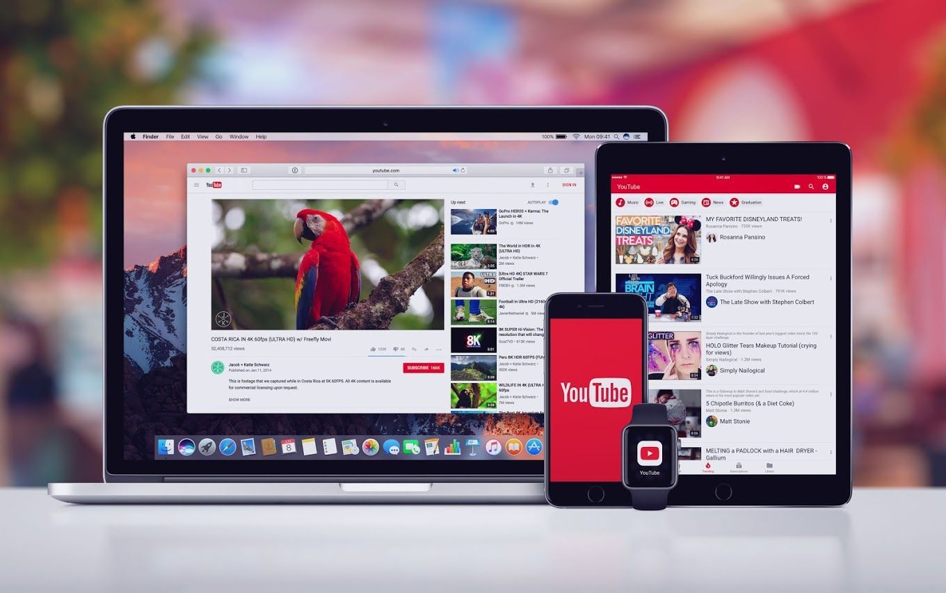 Laptop, tablet, phone, and smartwatch displaying YouTube videos and lists on a colorful background