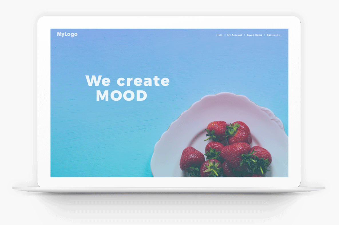White laptop displaying a blue webpage with “We create MOOD” and strawberries in a bowl