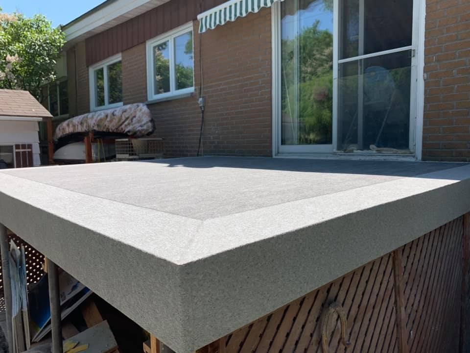 Une maison en brique avec une porte coulissante en verre et une terrasse en membrane de pvc.