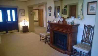Empty living room with fireplace, blue door, and beige carpet in a softly lit home interior