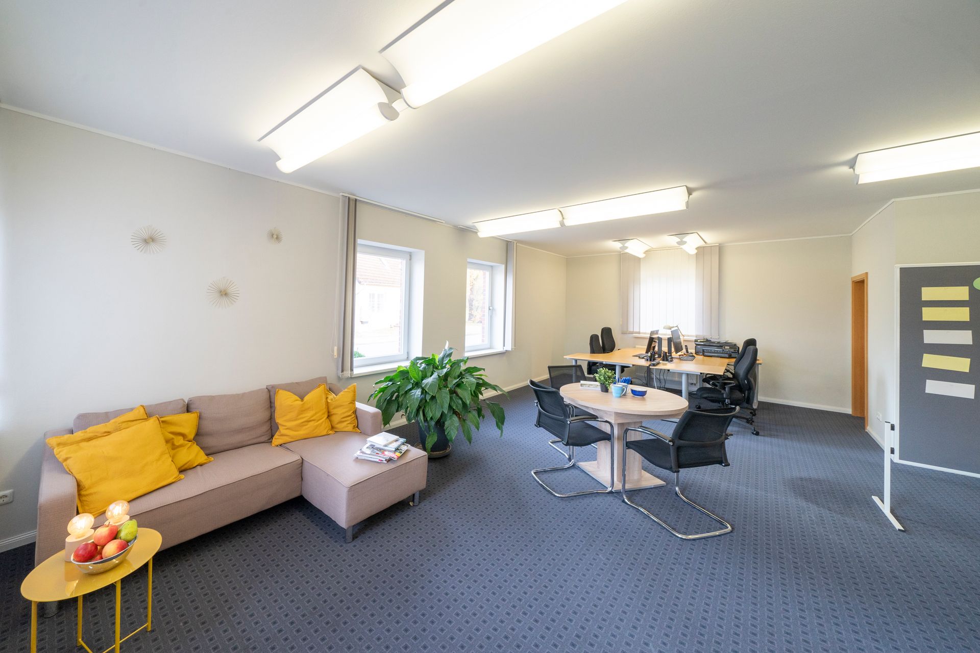 Ein Wohnzimmer mit Couch, Tisch und Stühlen.