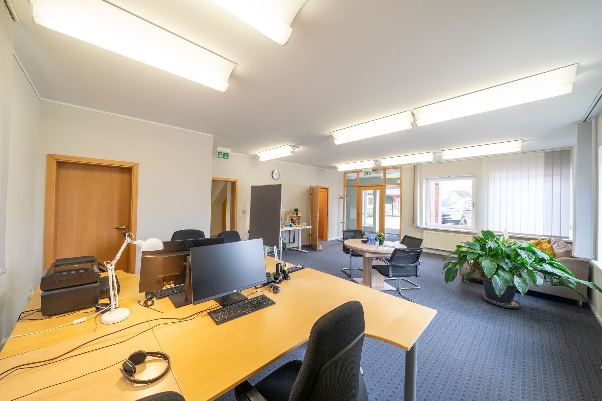 Ein großes Büro mit vielen Schreibtischen und Stühlen.