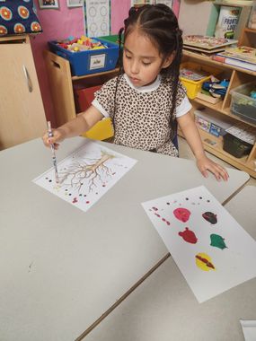 Infant Child Care — A Young Girl is Painting a Tree in Columbus, OH Infant Child Care — A Young Girl is Painting a Tree in Columbus, OH