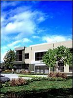 Modern office building with large windows, trees, and landscaped lawn under a bright blue sky