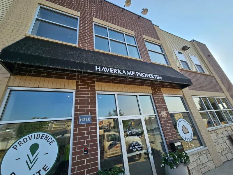 Exterior of Haverkamp Properties building with a black awning and large windows.