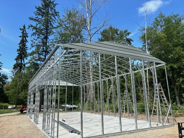 A large metal structure is being built in the middle of a dirt field.