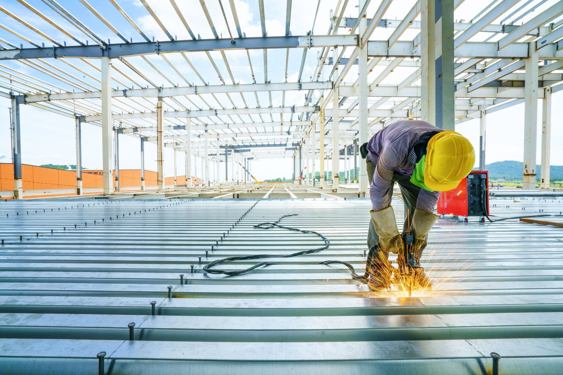 Welder welding rebar shear keys on a metal deck slab of a mezzanine floor under construction
