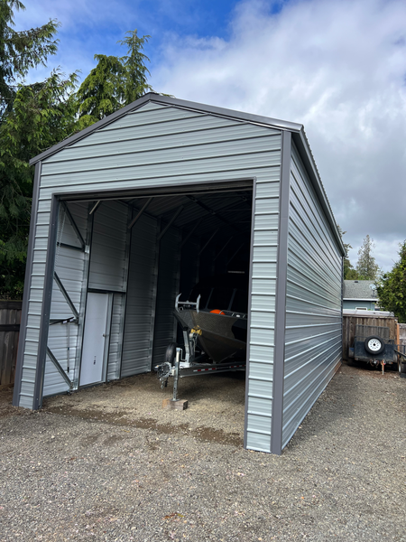 A boat is parked in a garage with the door open.