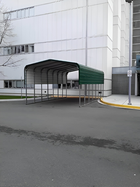 A green carport is in front of a white building.