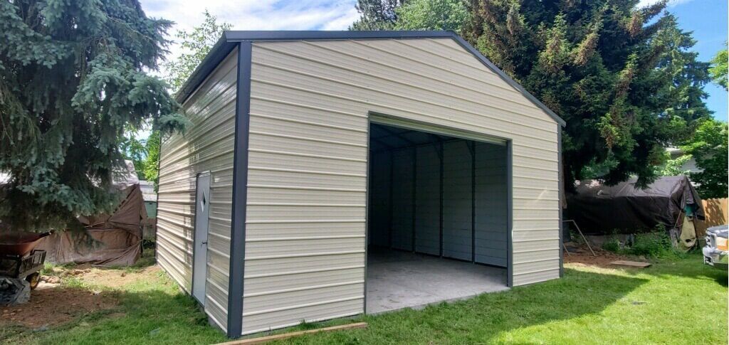 A metal garage is sitting in the middle of a lush green yard.