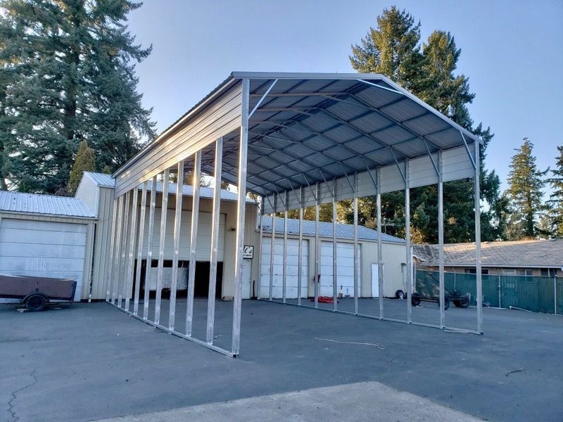 A large metal structure with a roof is sitting in a parking lot.