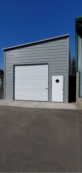 A garage with a white door and a white garage door.