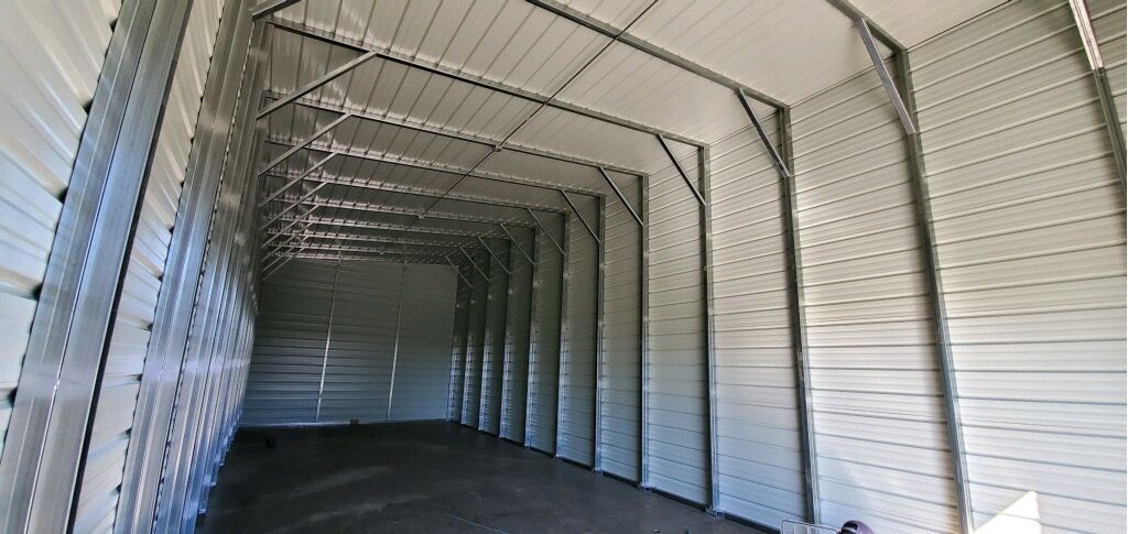 The inside of a large metal building with a black floor.