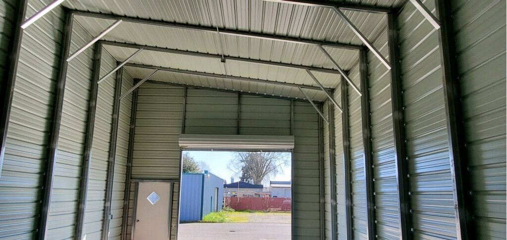 The inside of a metal building with a garage door open.