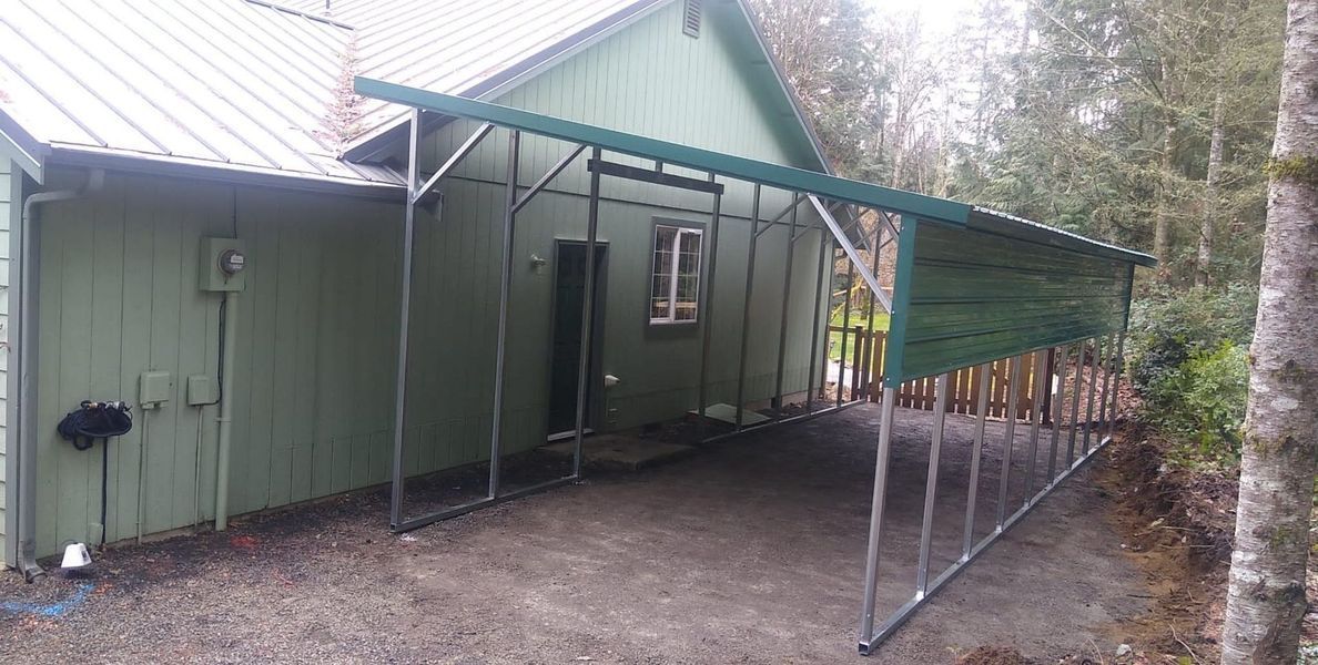 A metal carport is sitting in front of a house.
