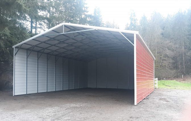 A red and white metal building is sitting in a gravel area.