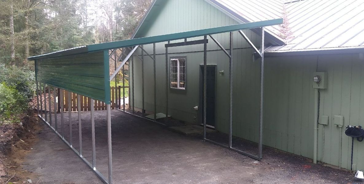 A carport with a green roof is attached to the side of a house.