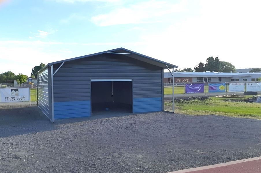 A gray and blue metal building with a garage door.