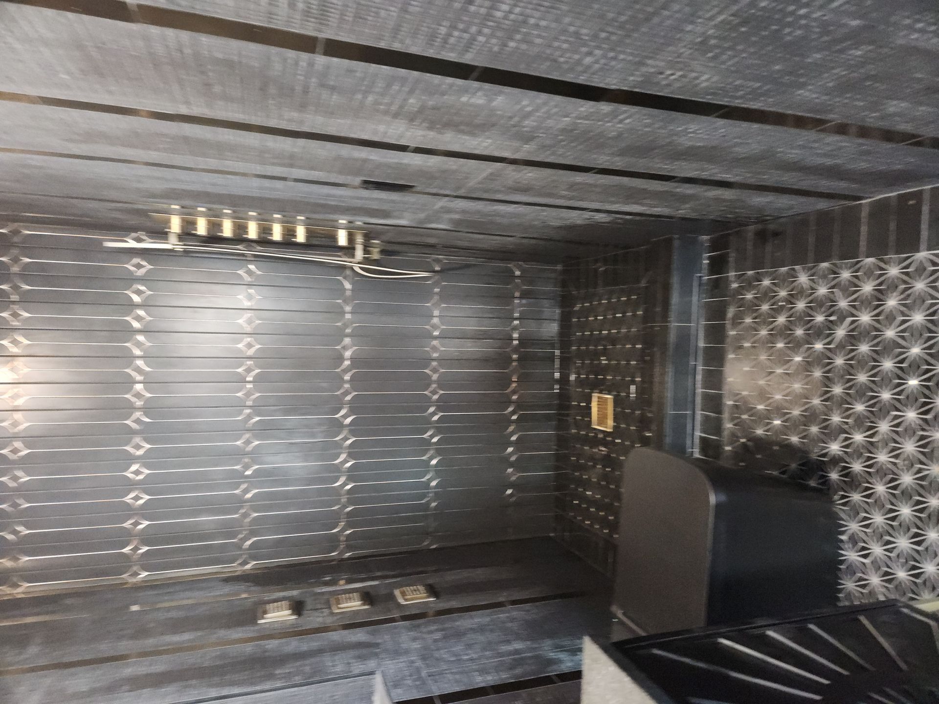 Interior of a metallic oven or appliance, with reflective walls and a small black component on the right