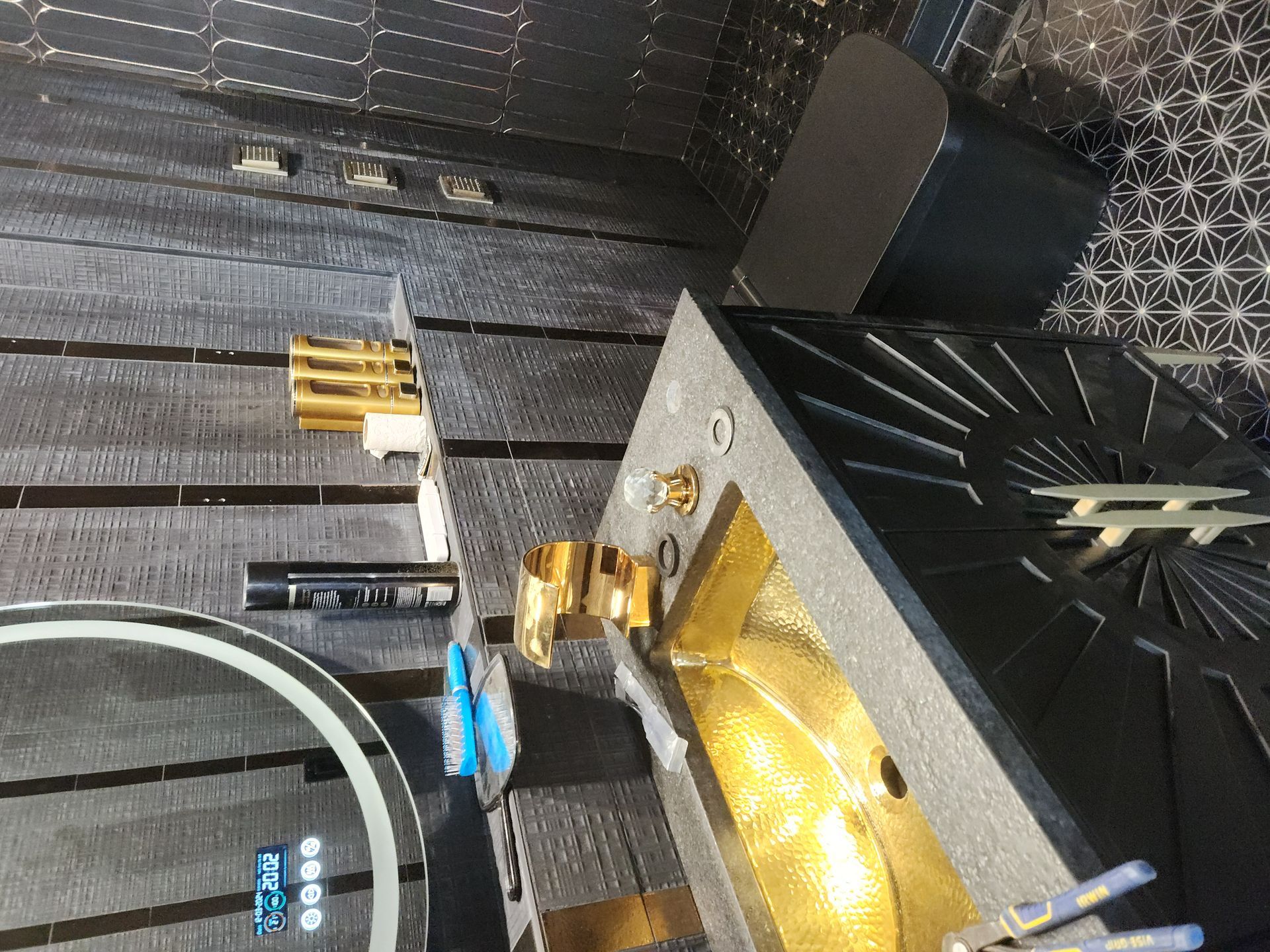 Small altar with candles, gold decor, and a lit cross on a dark patterned wall