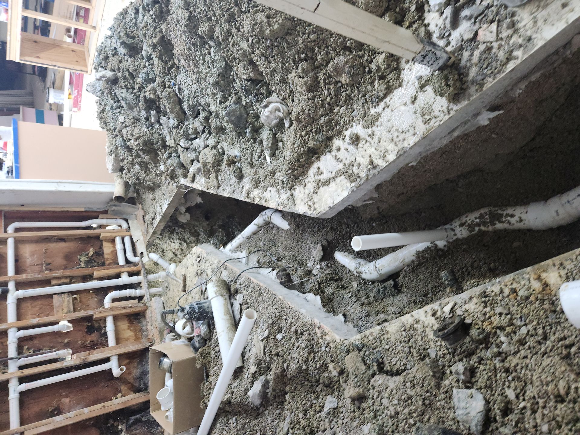 Collapsed concrete rubble and exposed pipes at a damaged construction site
