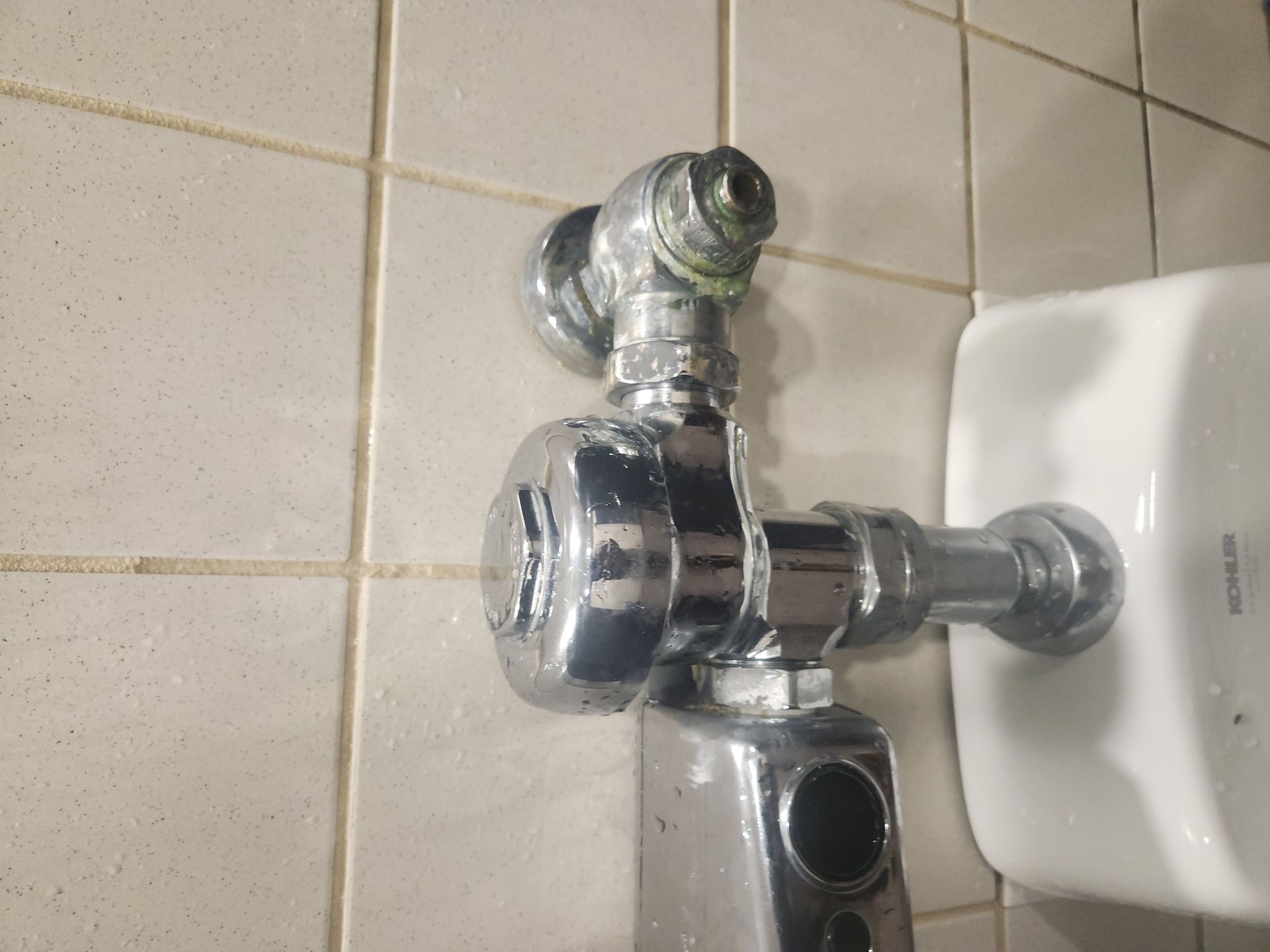 Chrome shower fixture mounted on a tiled bathroom wall with a white soap holder