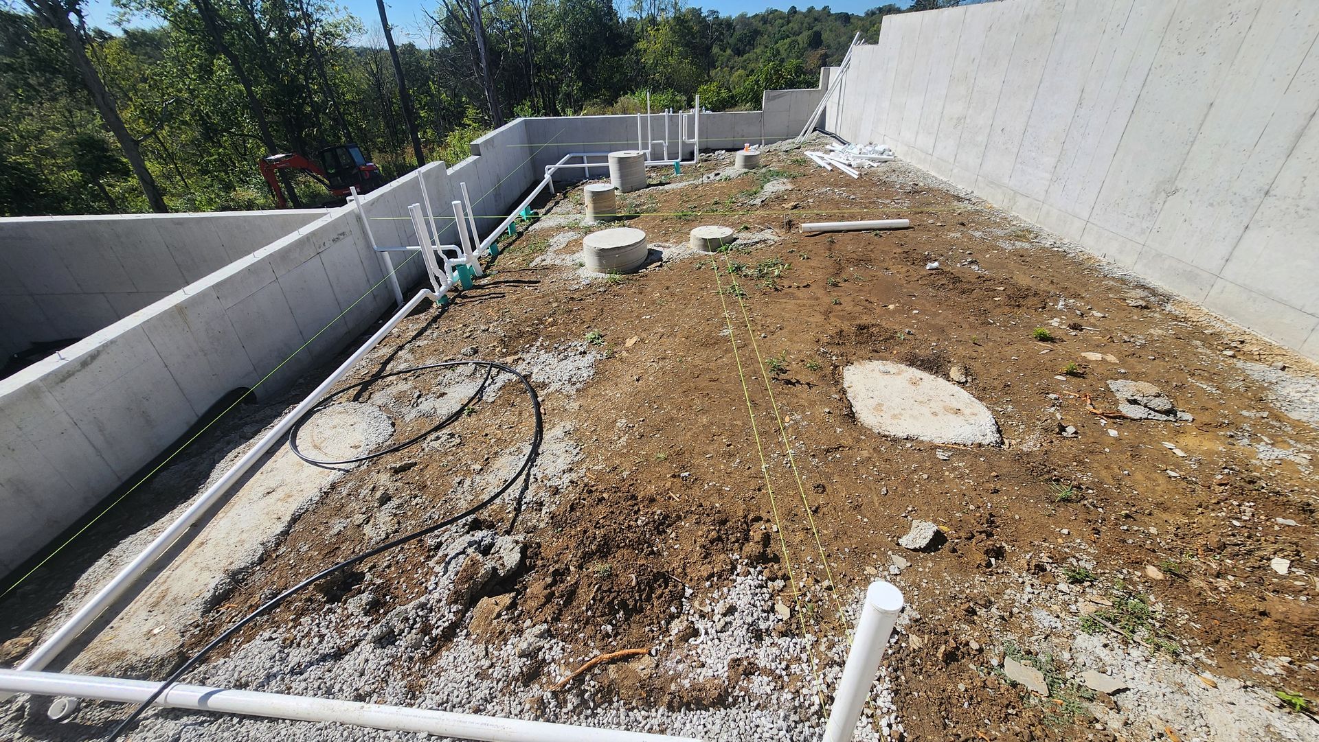 Dried, patchy rooftop garden bed with irrigation lines and white parapet walls under bright sunlight