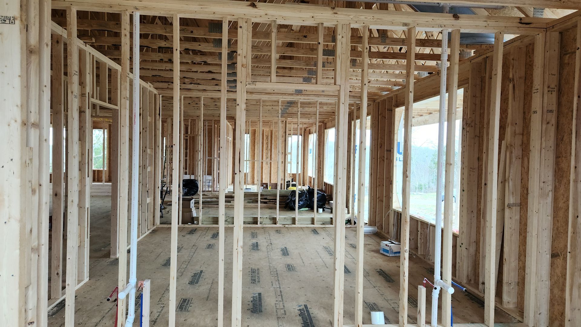 Interior of a house under construction with exposed wood framing and unfinished walls