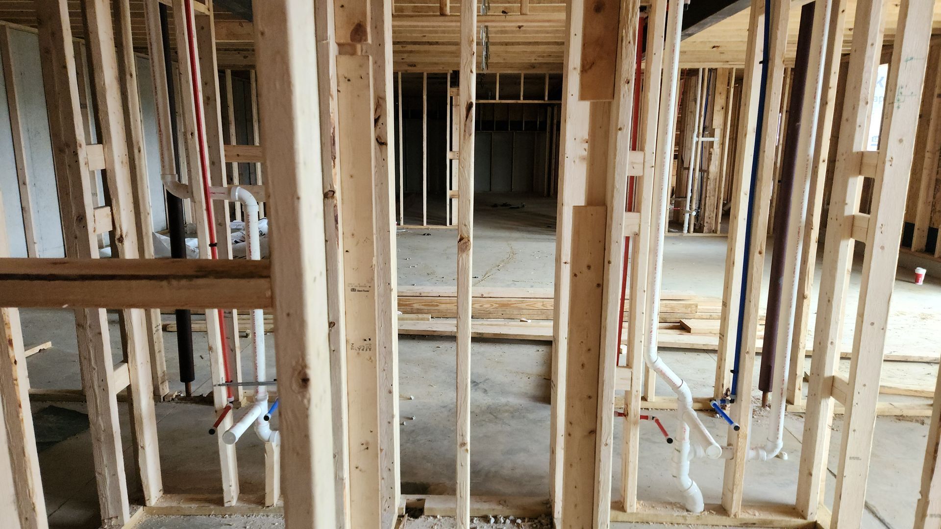 Interior of a house under construction with exposed wooden framing and unfinished walls.