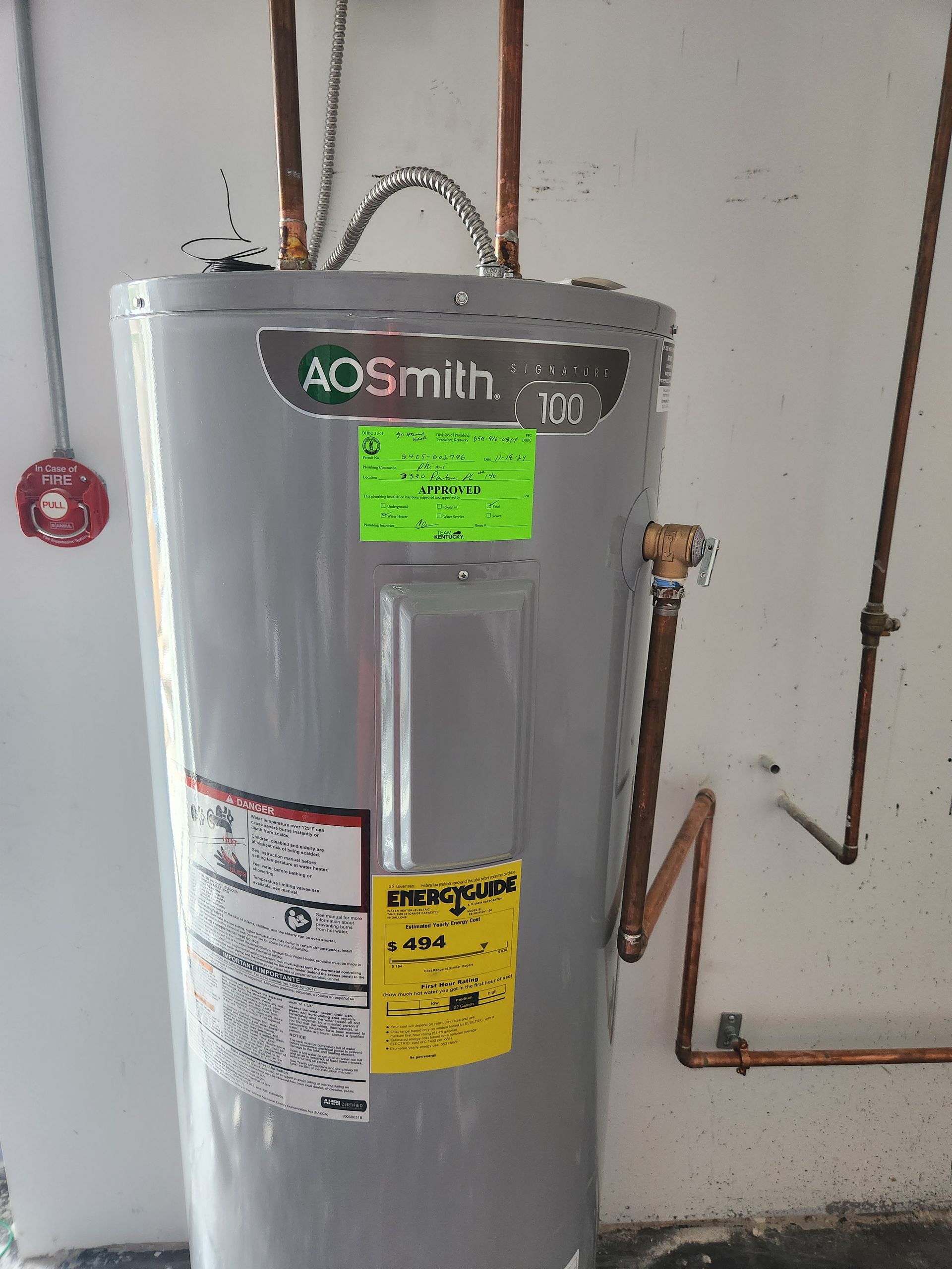 AO Smith water heater in a utility room with visible pipes and wall-mounted controls